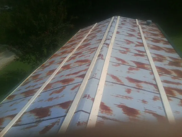 Rusted metal roof panels with new wood purlins before replacement — Storm Damage Roof Repair in Coal Center by Roofing Brothers