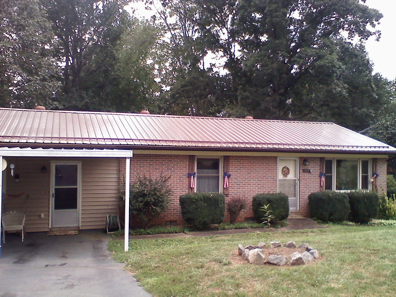 Bronze metal roof and carport on a brick ranch home — Roof Repair work by our crew in Coal Center